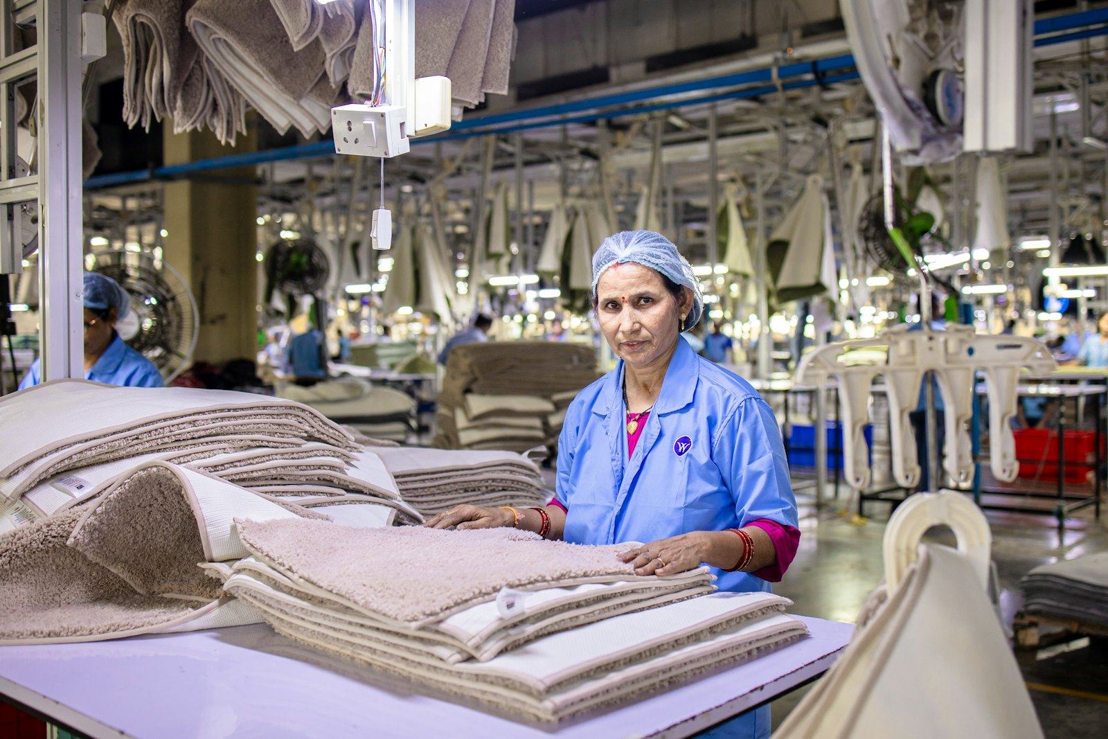 A worker checking finished garments on a production line